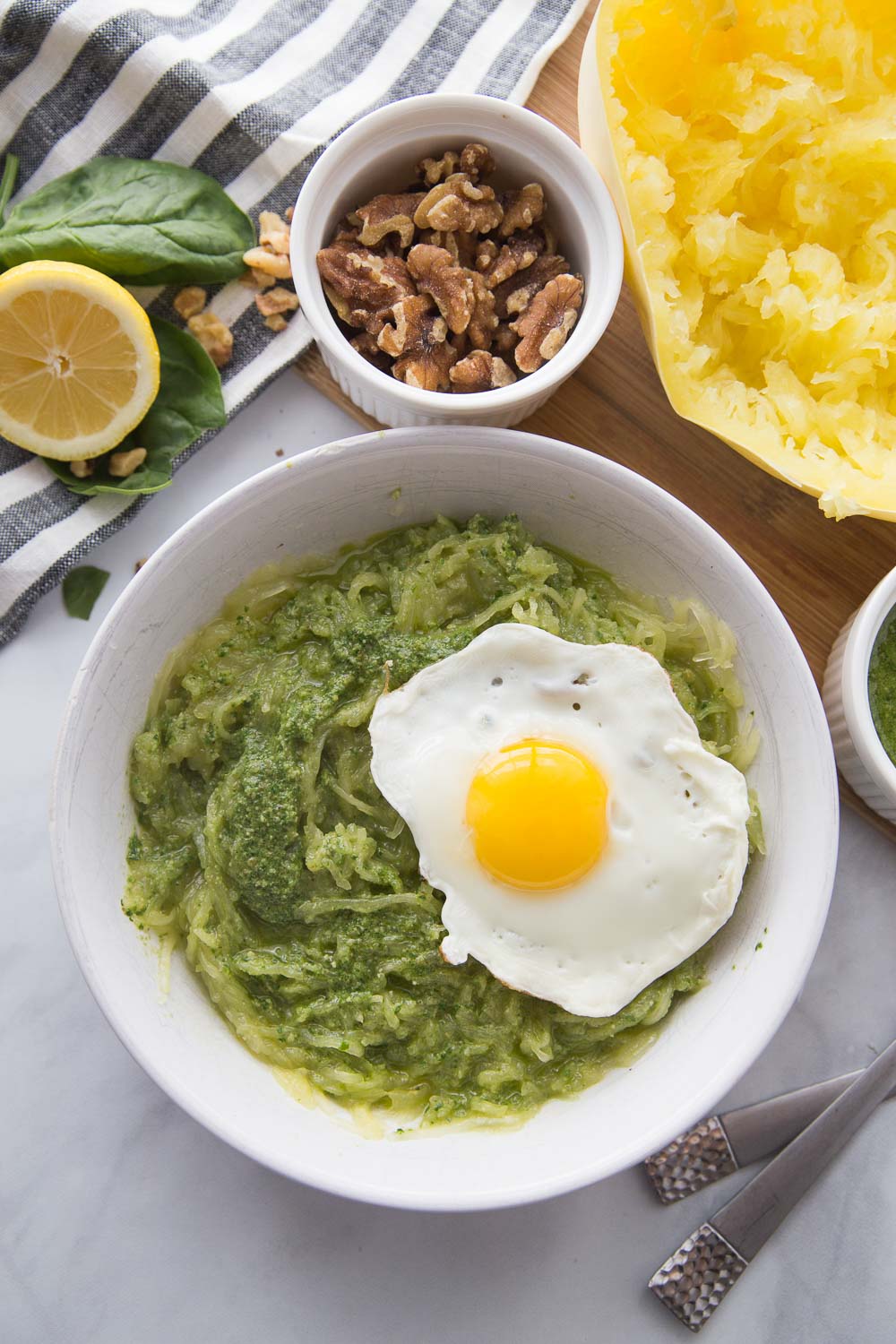 A white bowl with spaghetti squash pesto and a fried egg