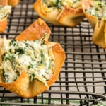 Filled spinach artichoke cups on a cooling rack