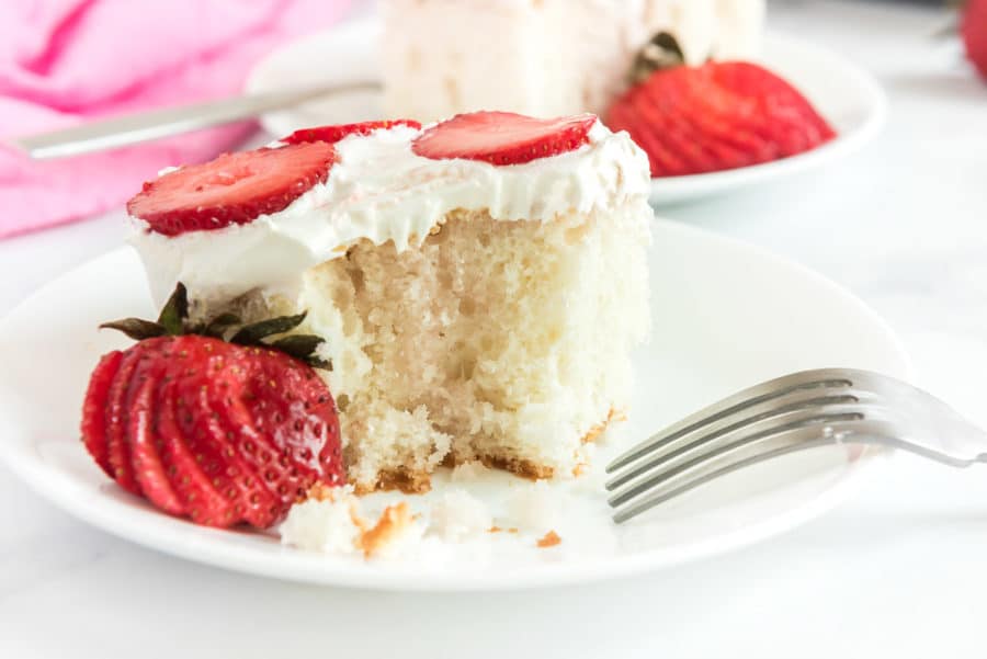 A close up piece of strawberry poke cake