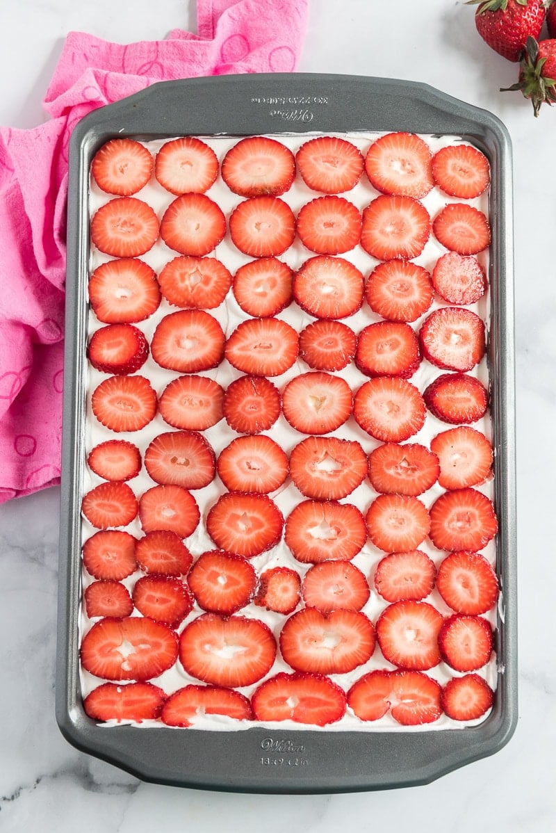 Strawberry poke cake with fresh strawberries