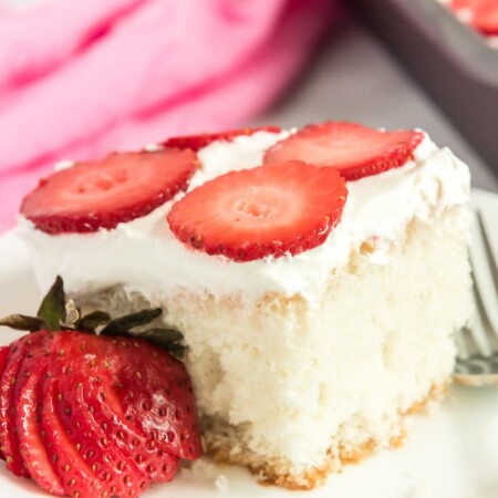A square piece of strawberry poke cake