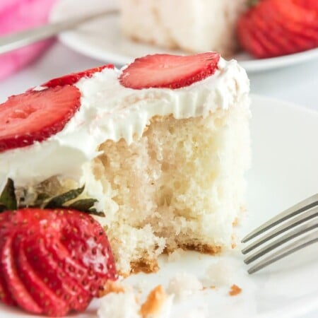 Strawberry poke cake with whipped cream on top