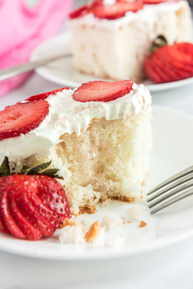 Strawberry poke cake with whipped cream on top
