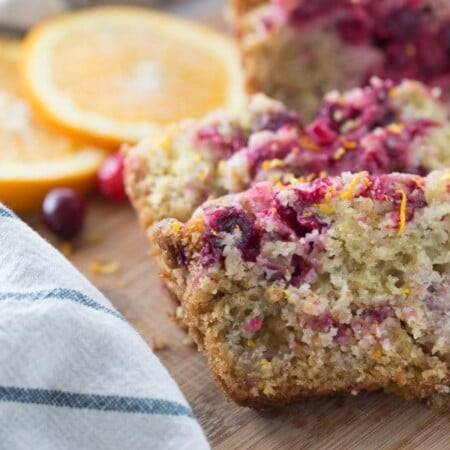 Sliced cranberry orange bread on a cutting board