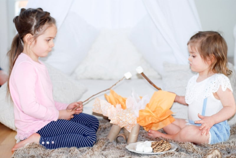 Kids camping indoors and roasting marshmallows