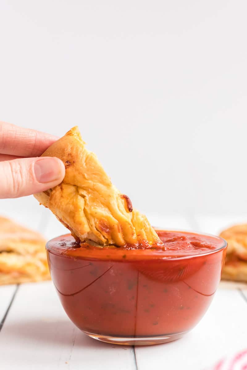 Pizza loaf being dipped in sauce