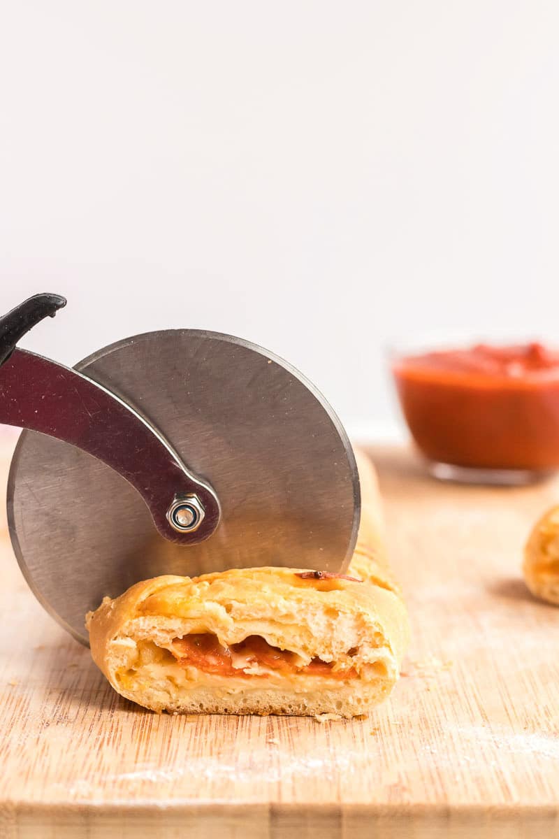 Cutting pizza loaf with a pizza cutter