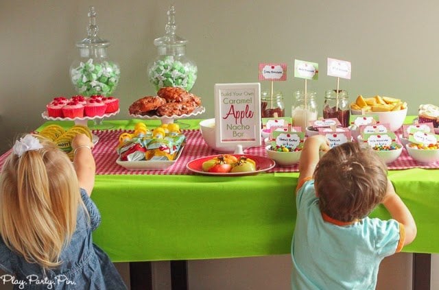 2 kids picking their toppings for their apples