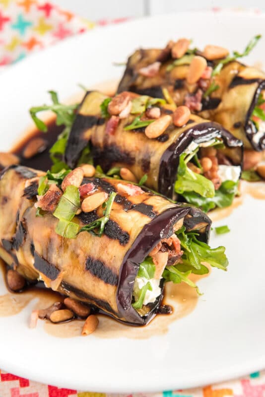 Three eggplant rolls filled with arugula and bacon
