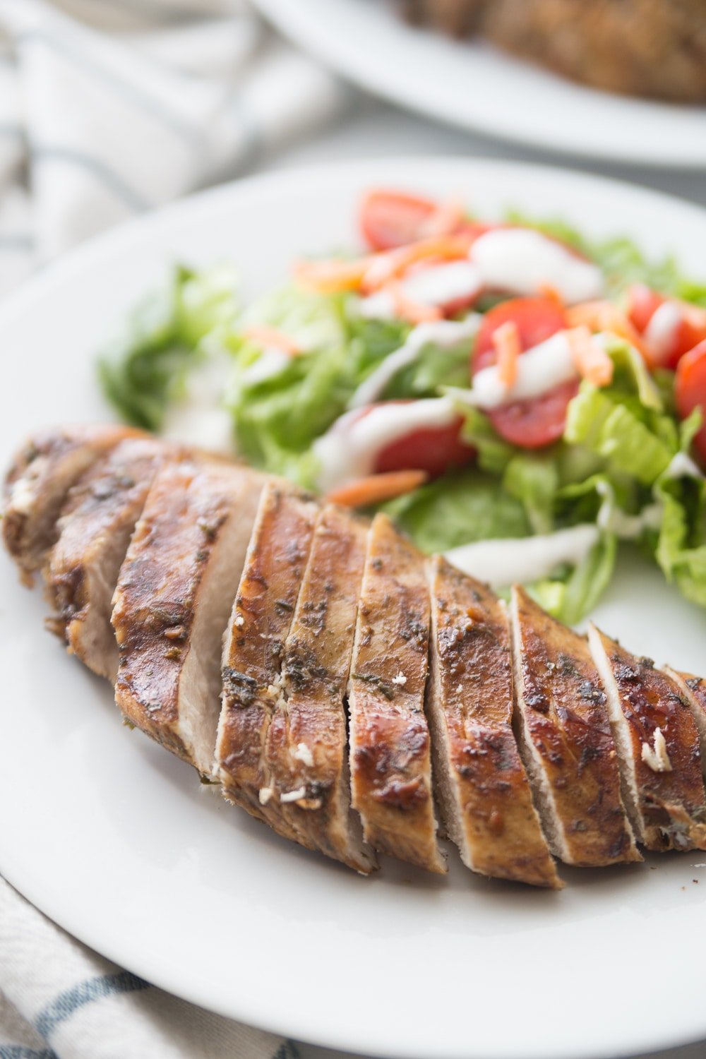 Sliced baked balsamic chicken on a white plate