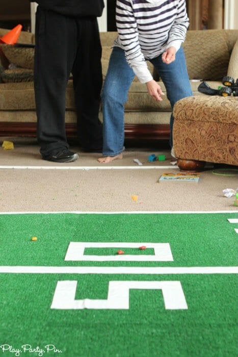 Fun Super Bowl party games like this one where you have guests try to toss things to get them to land on football field lines! 