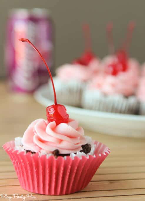 Cherry coke cupcakes topped with a cherry buttercream frosting