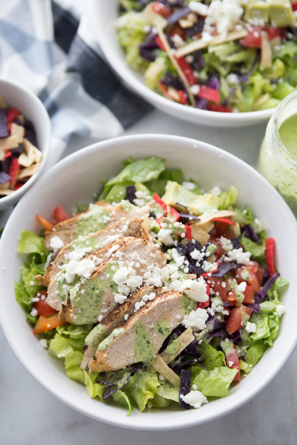 Two bowls of southwestern chicken salad with dressing