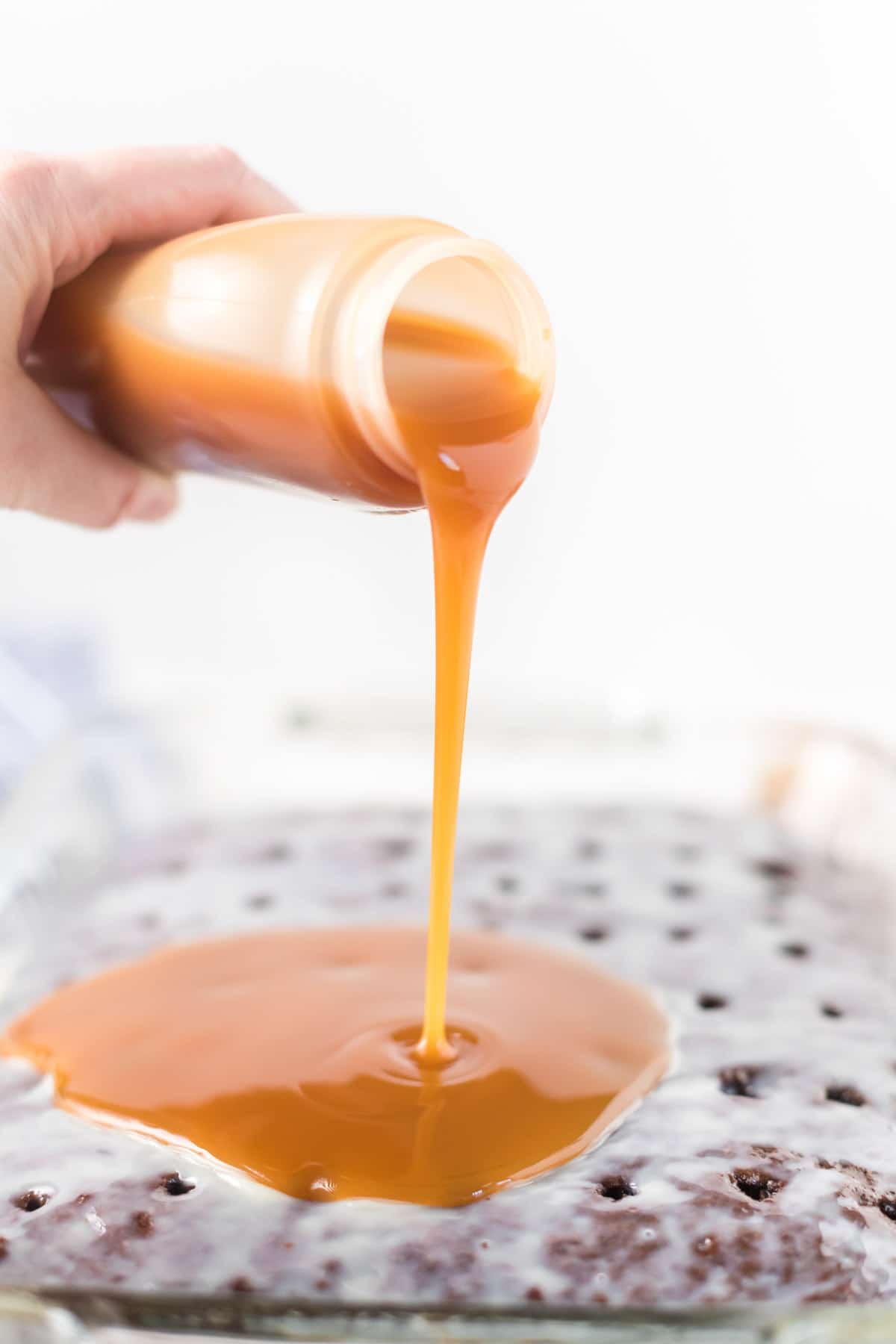 Pouring caramel over chocolate cake