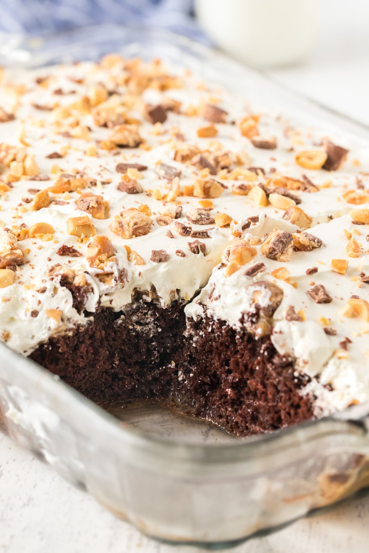 Snickers poke cake with a piece cut out