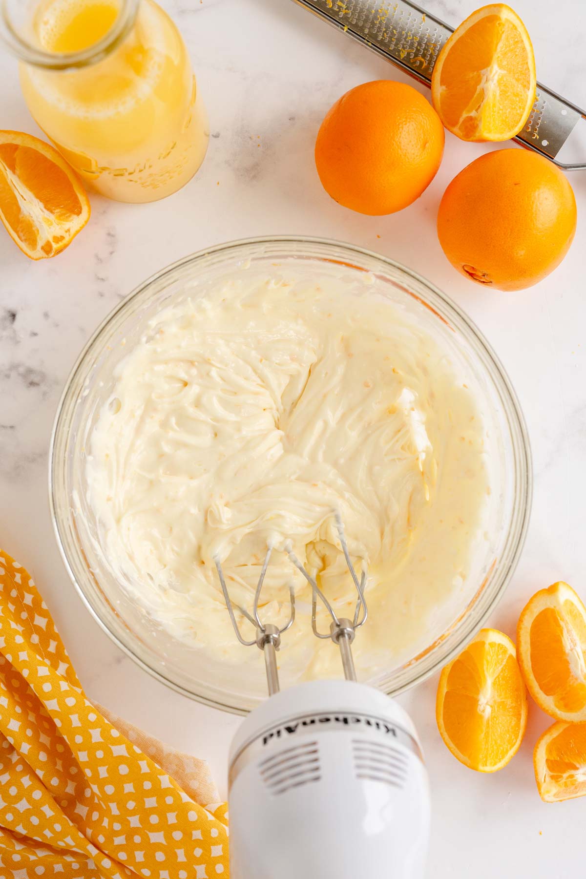 glass bowl with a hand mixer and fruit dip in the bowl