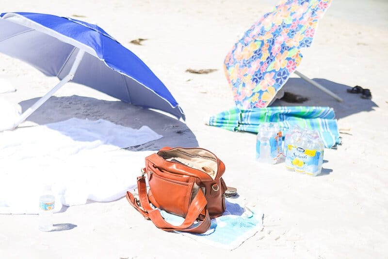 Beach bag and beach umbrellas on the sand