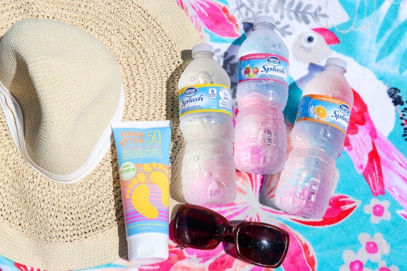 water bottles and sunglasses on a beach towel