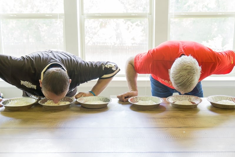 Men playing Thanksgiving games like eating a pie