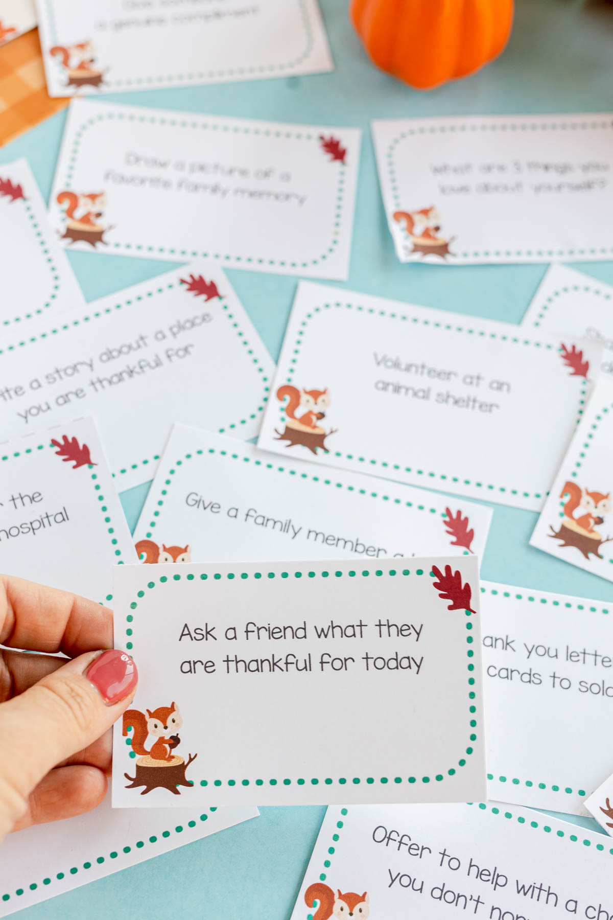 hand holding a card with a gratitude activity on it