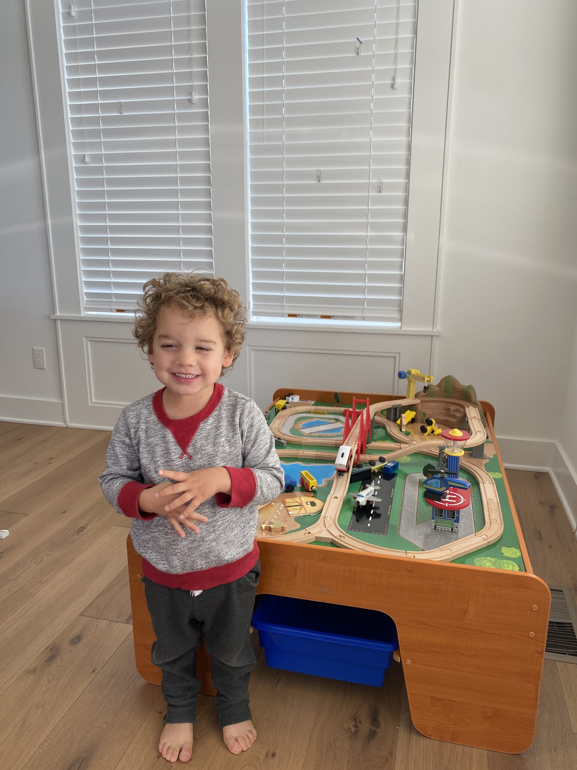 Kid standing in front of a train table