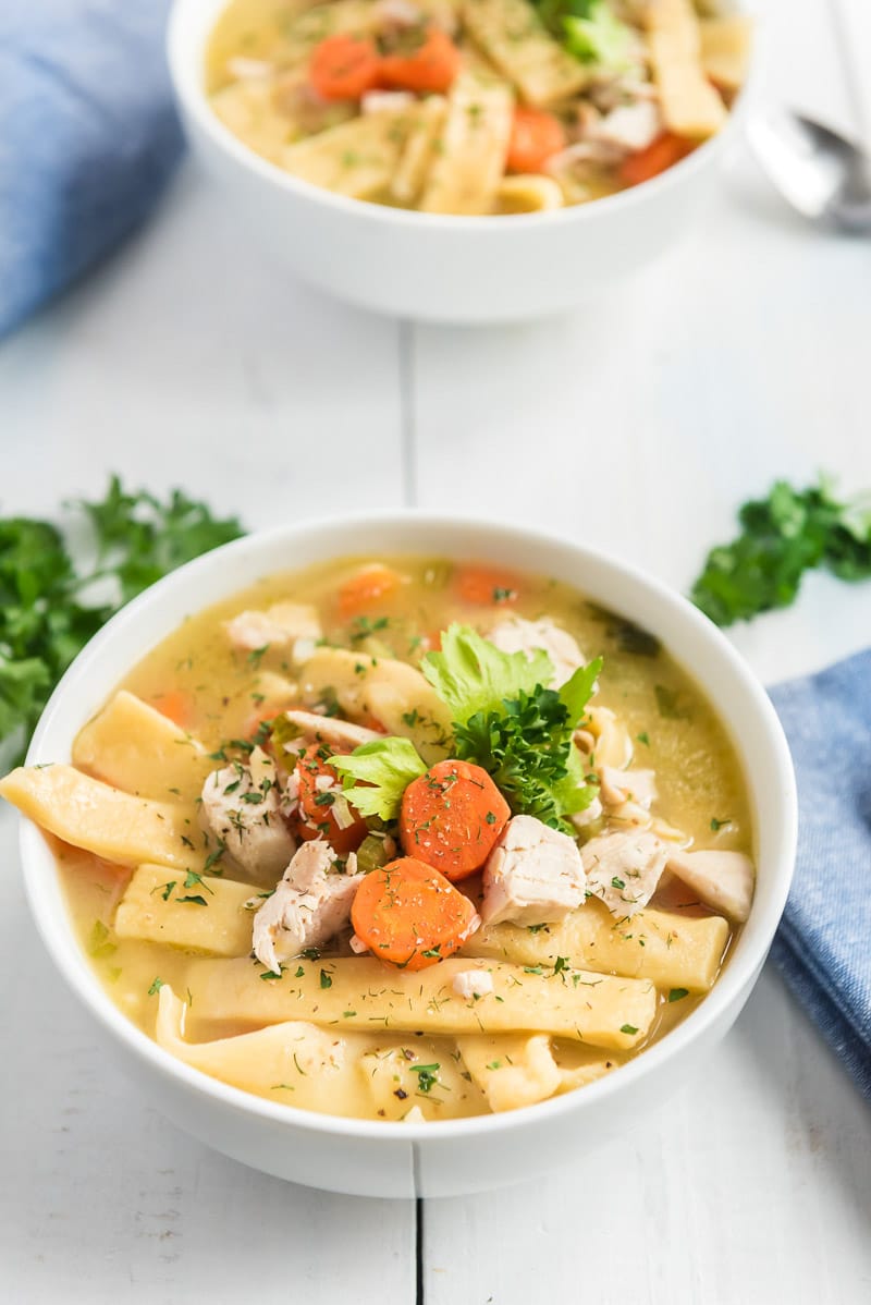 Two bowls of chicken noodle soup with egg noodles