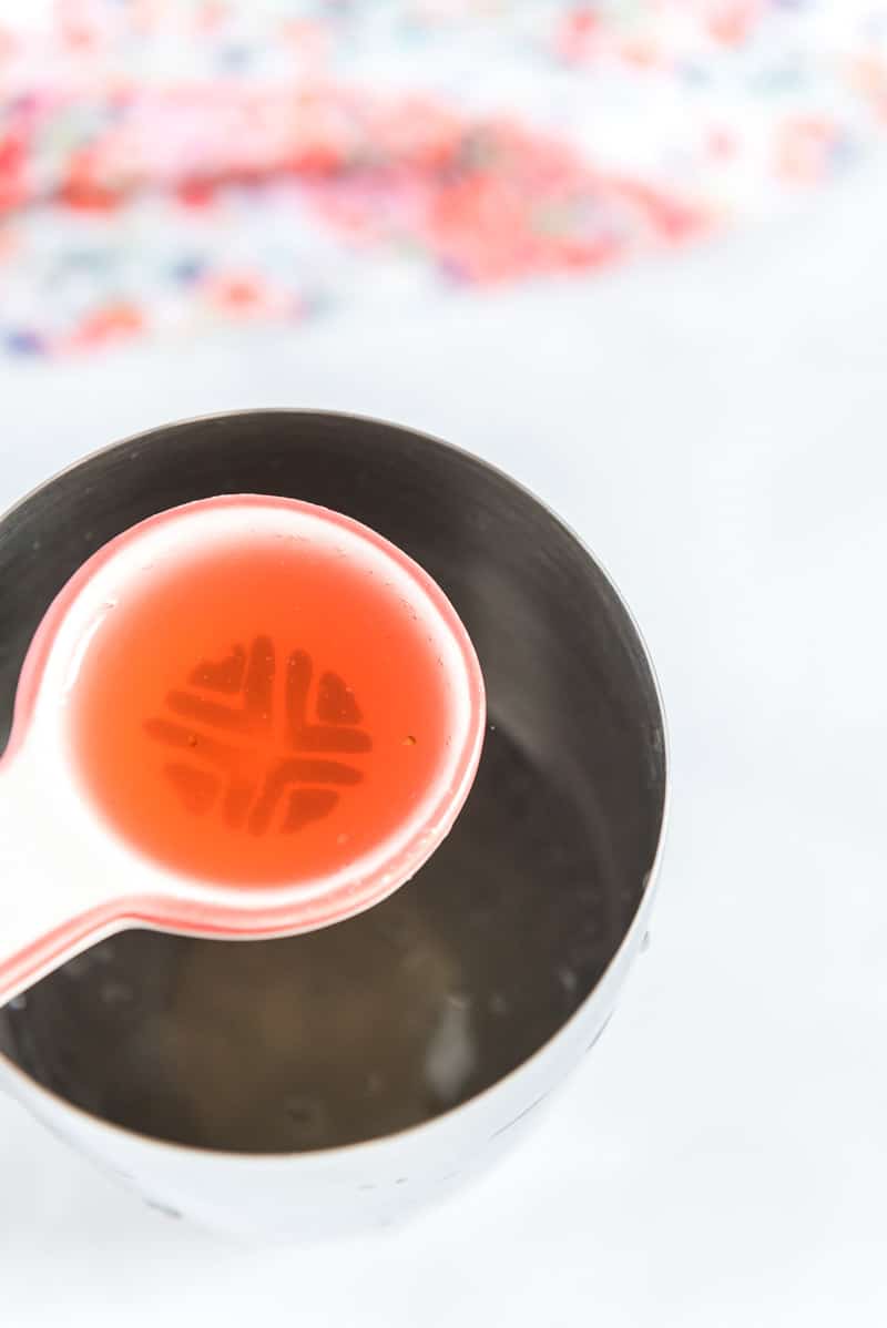 Adding simple syrup to a strawberry mocktail