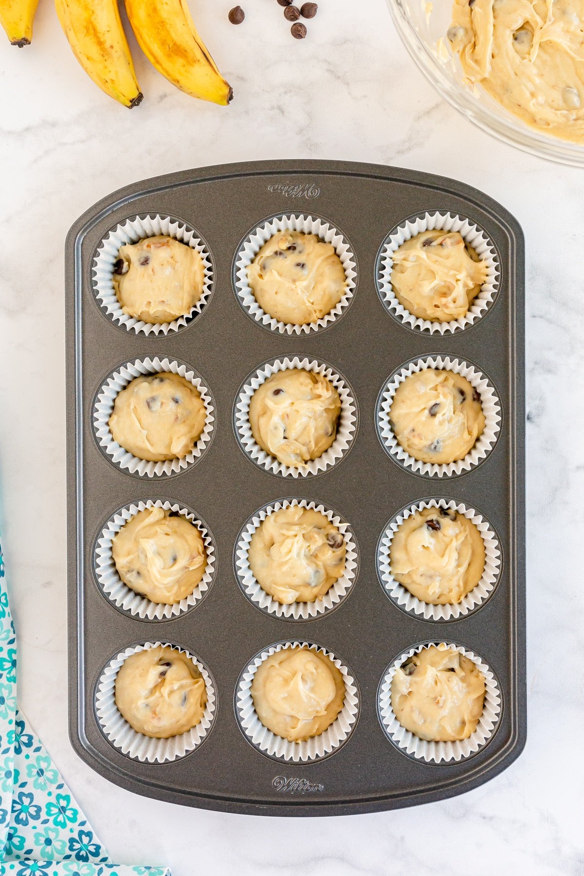 unbaked banana chocolate chip muffins in a muffin tin