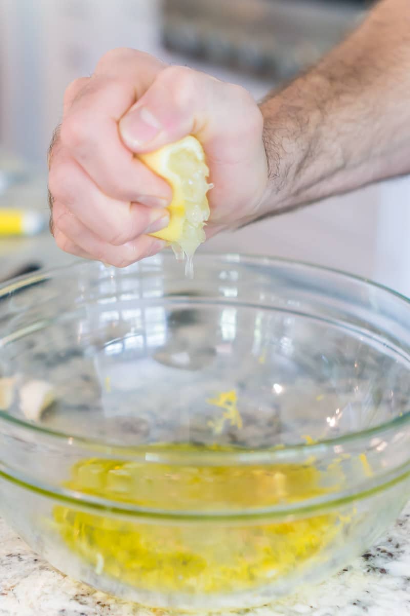 Squeezing a lemon into a Greek chicken marinade