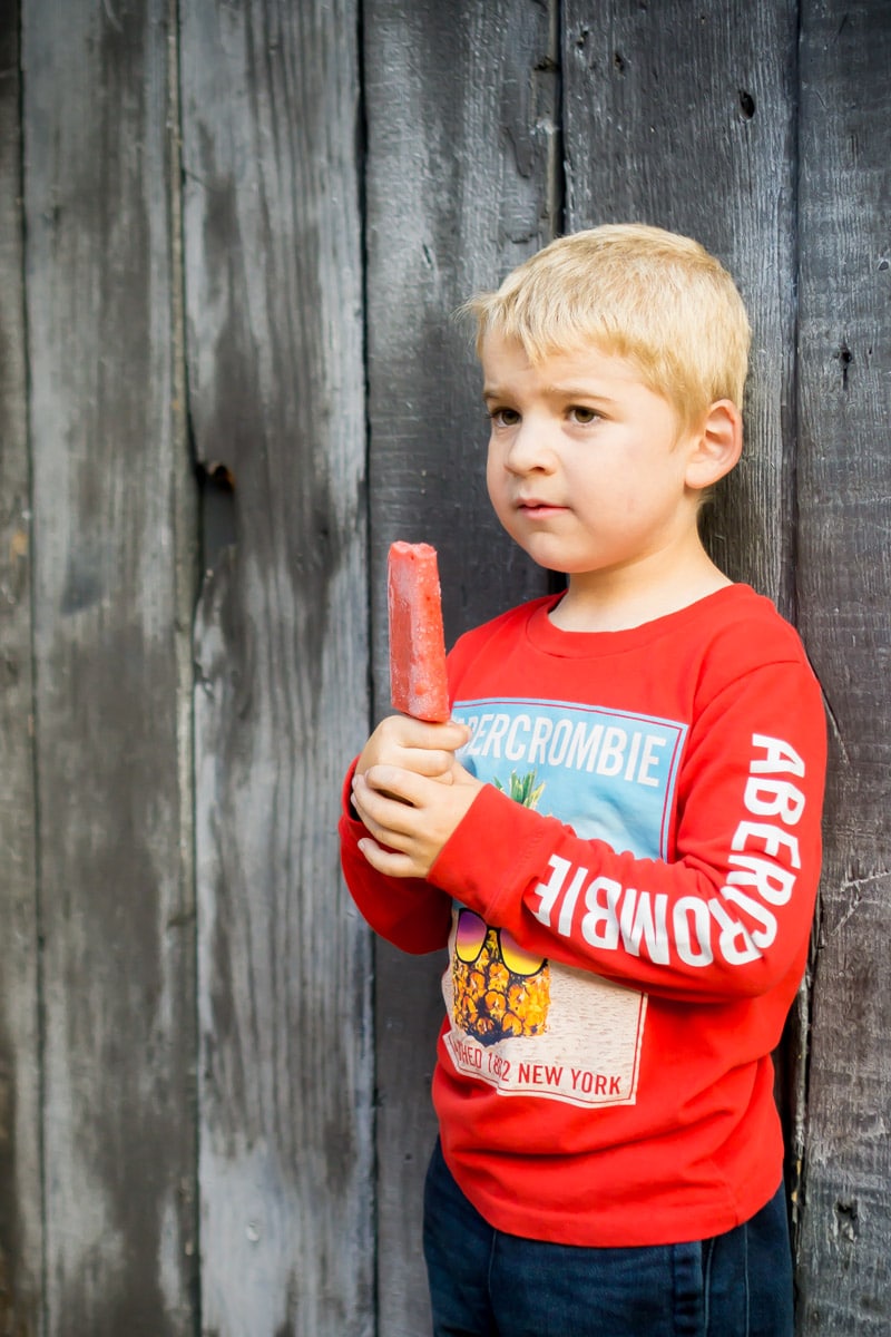 A kid with a popsicle after his first day of kindergarten