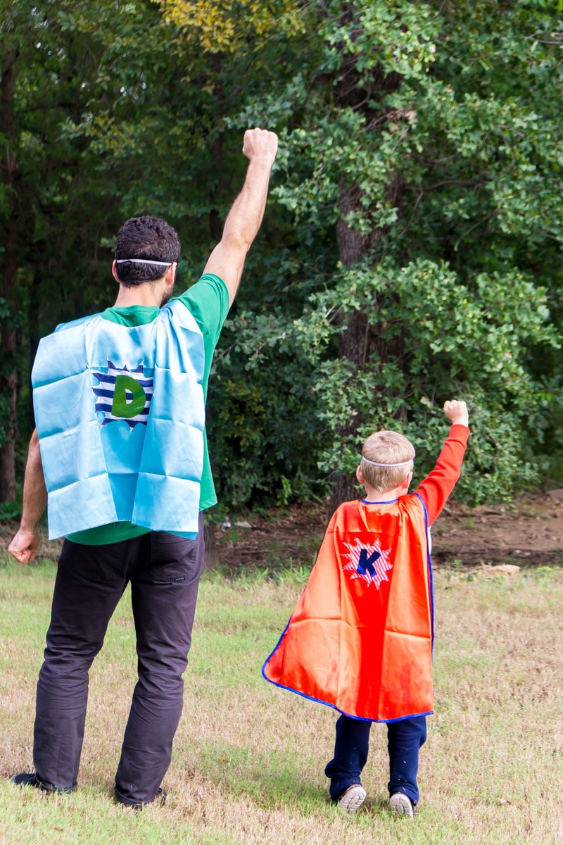 Father and son flying away in DIY superhero costumes