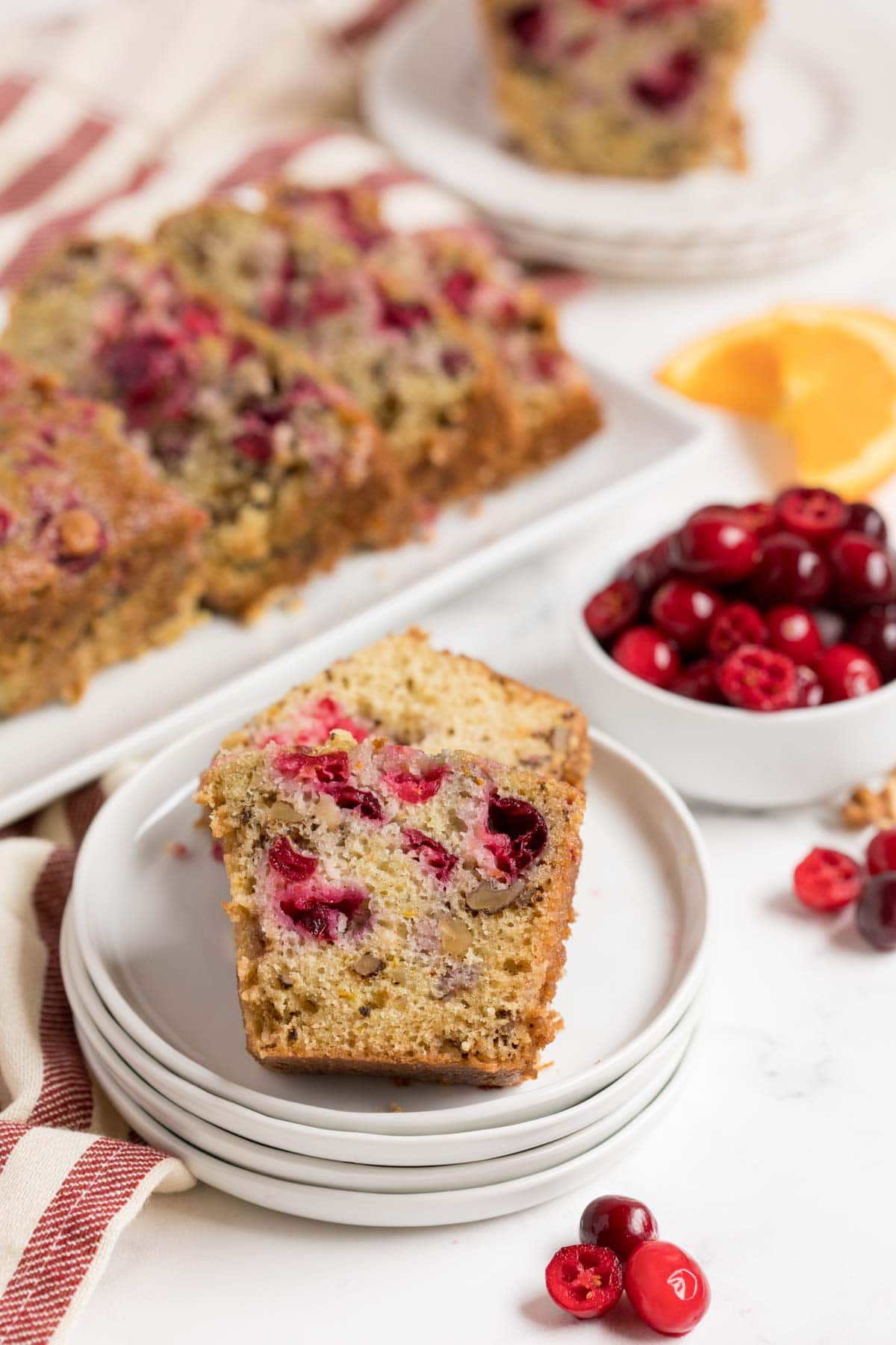 A slice of cranberry orange bread on a white plate
