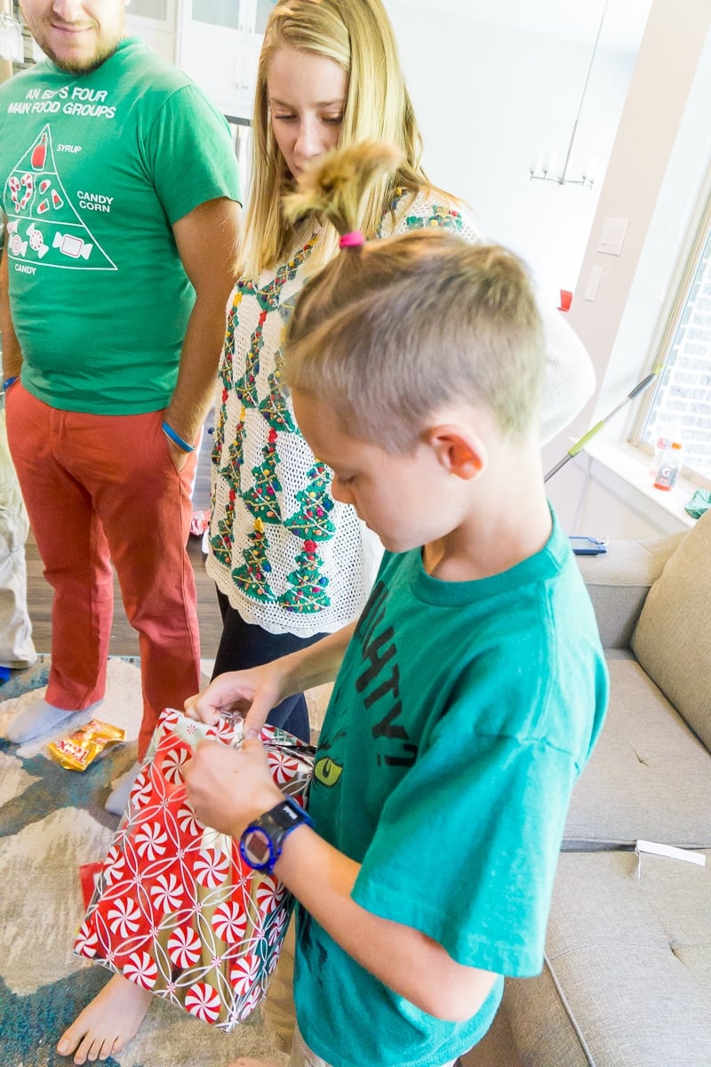 A kid opening a gift as part of a Never Have I Ever game