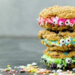 Monster cookie sandwiches stacked in a Halloween party food display