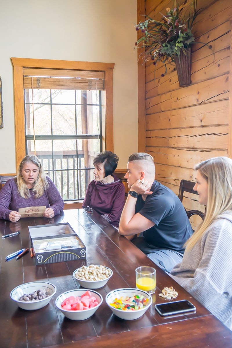 Group of people sitting at a table playing an escape room board game