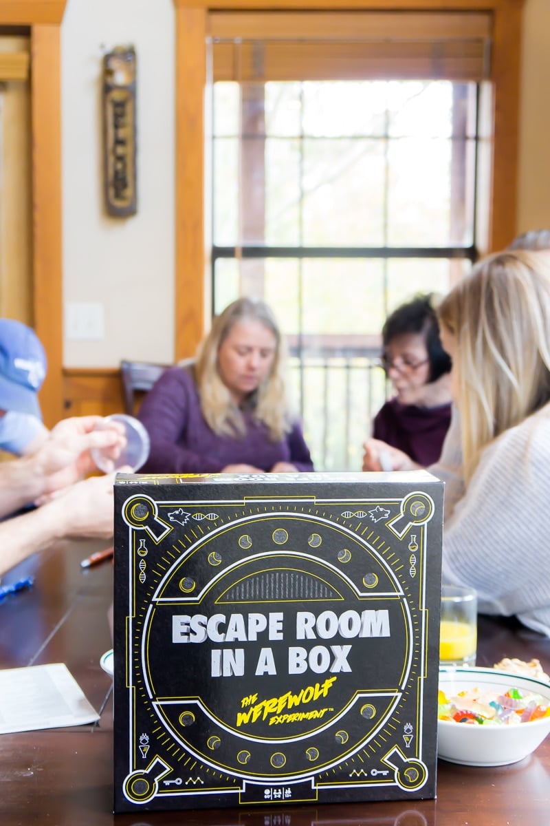 Adults playing the best escape room board game - Escape Room in a Box