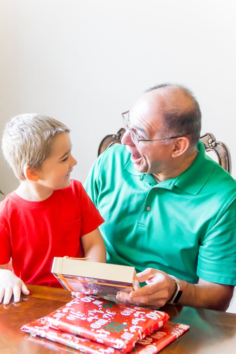 Grandpa with a surprised face opening his grandparents gifts