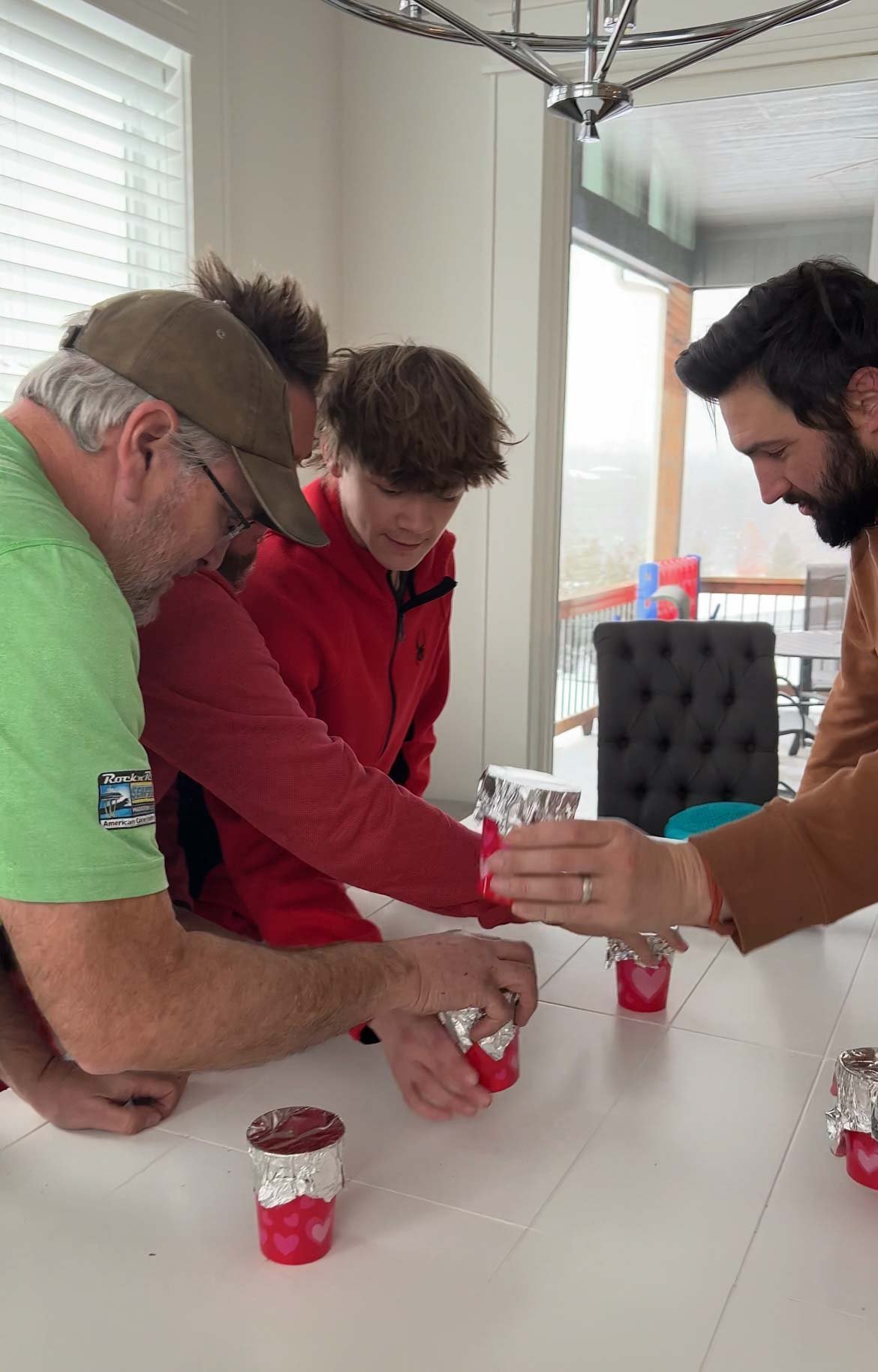 people grabbing cups on a white table