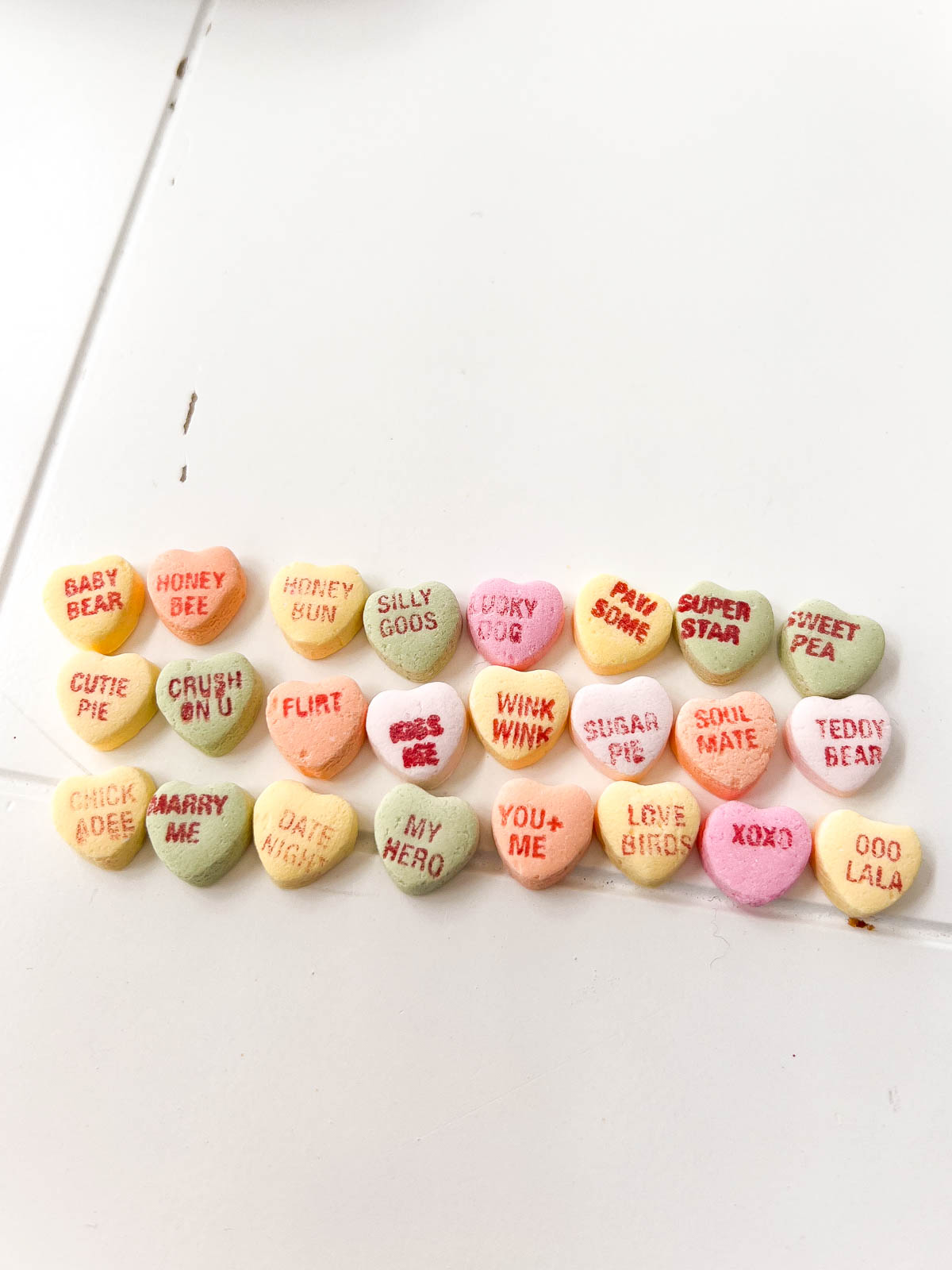 pile of conversation hearts on a white table