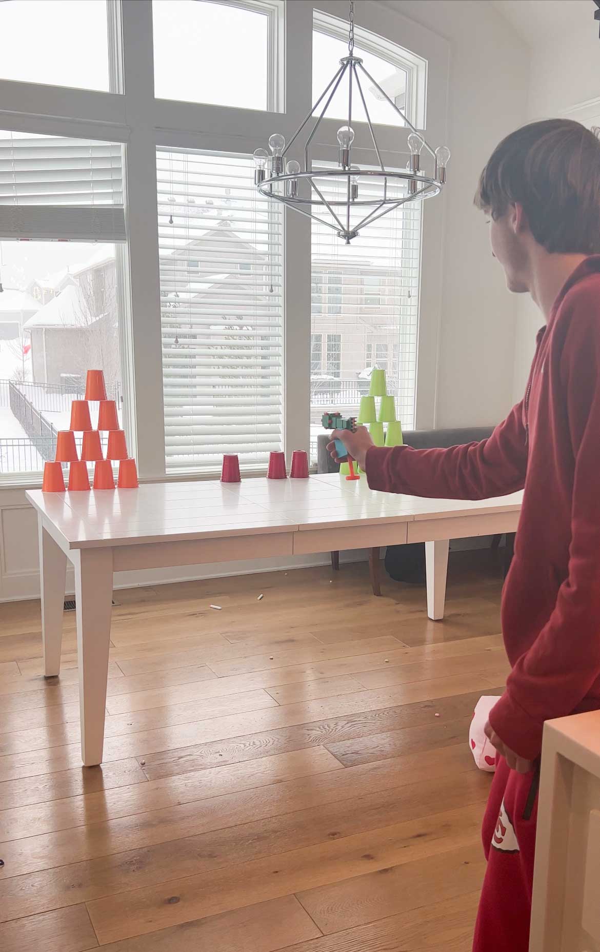 teen boy shooting a Nerf gun at cups