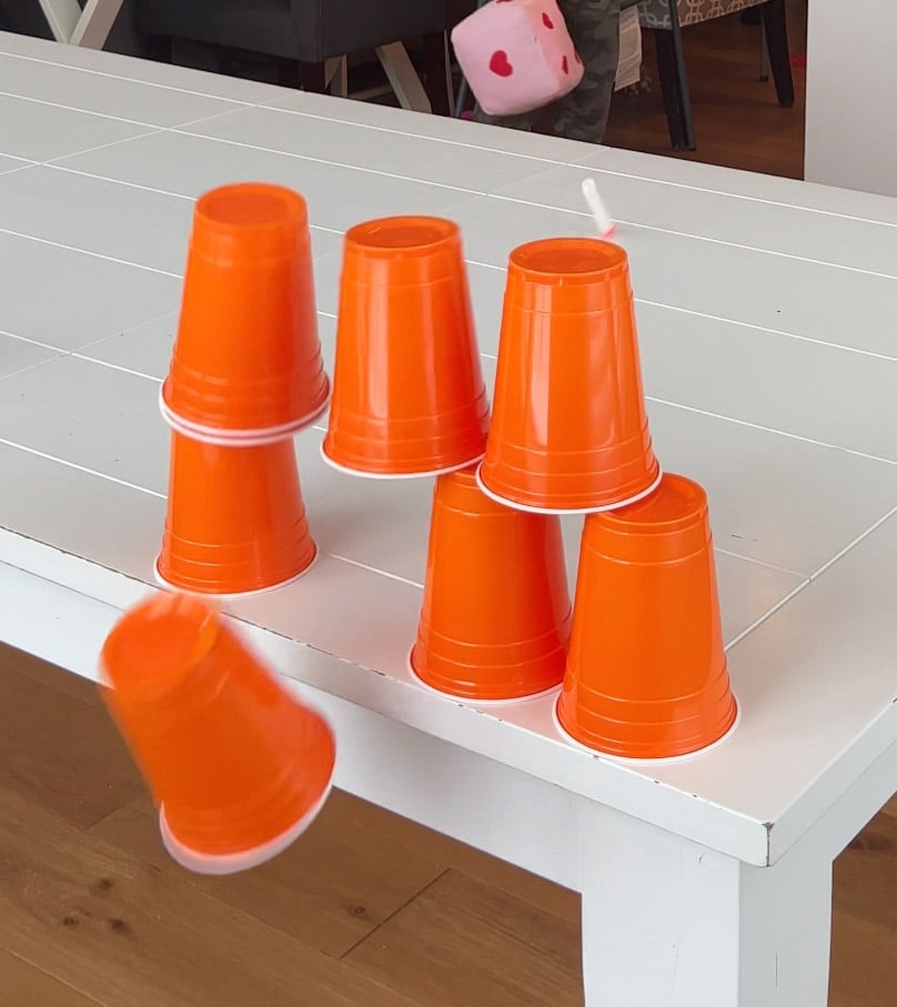 cup of towers falling off the back of a table