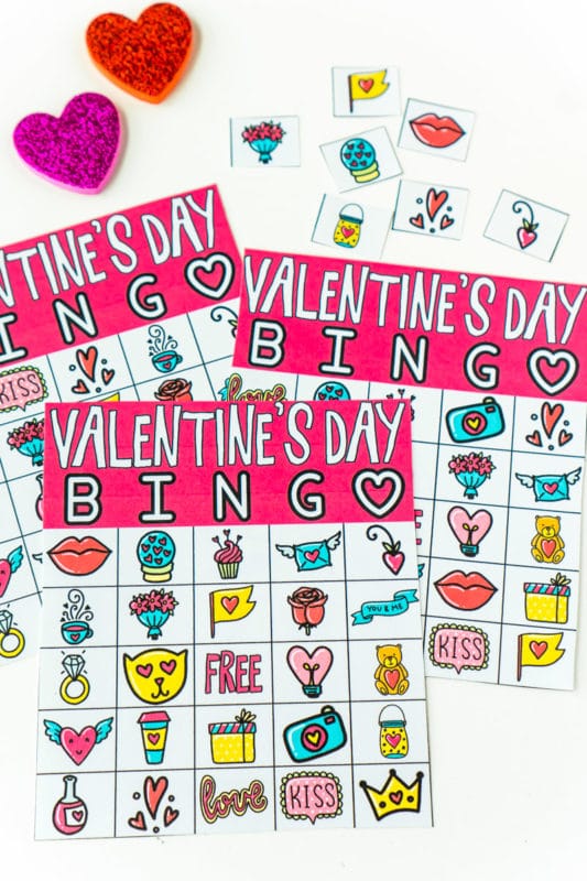 Three Valentine bingo cards with markers and master callers