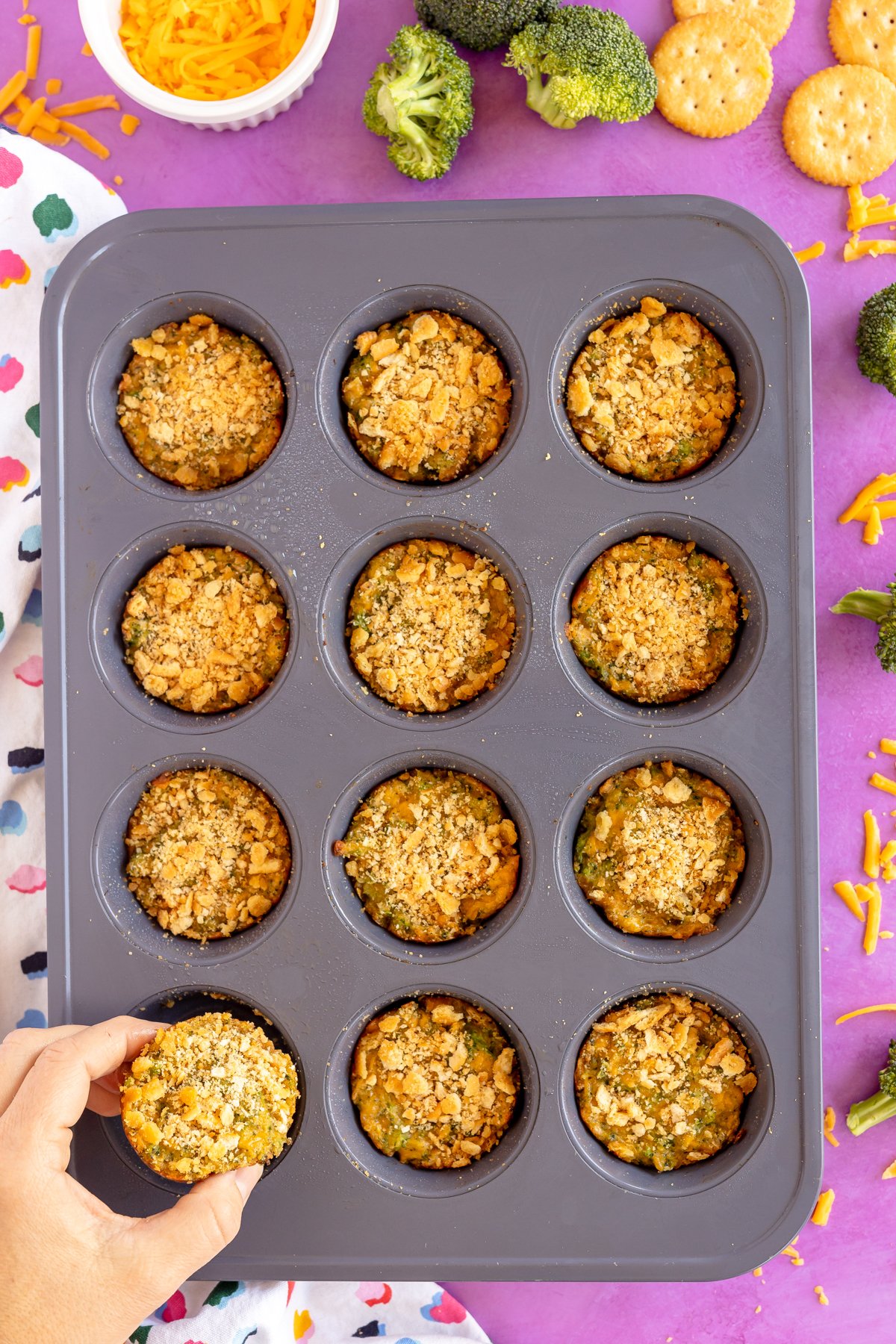 hand grabbing a broccoli bites in a muffin tin