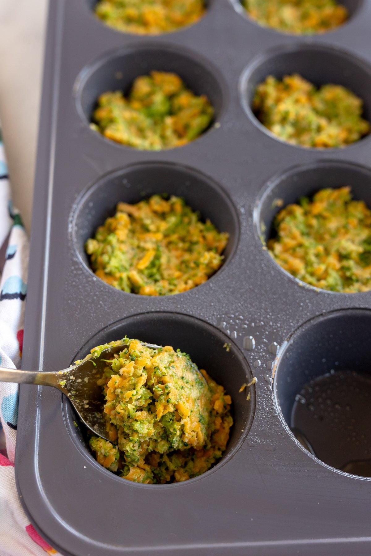 filling muffin tins with broccoli bites mixture