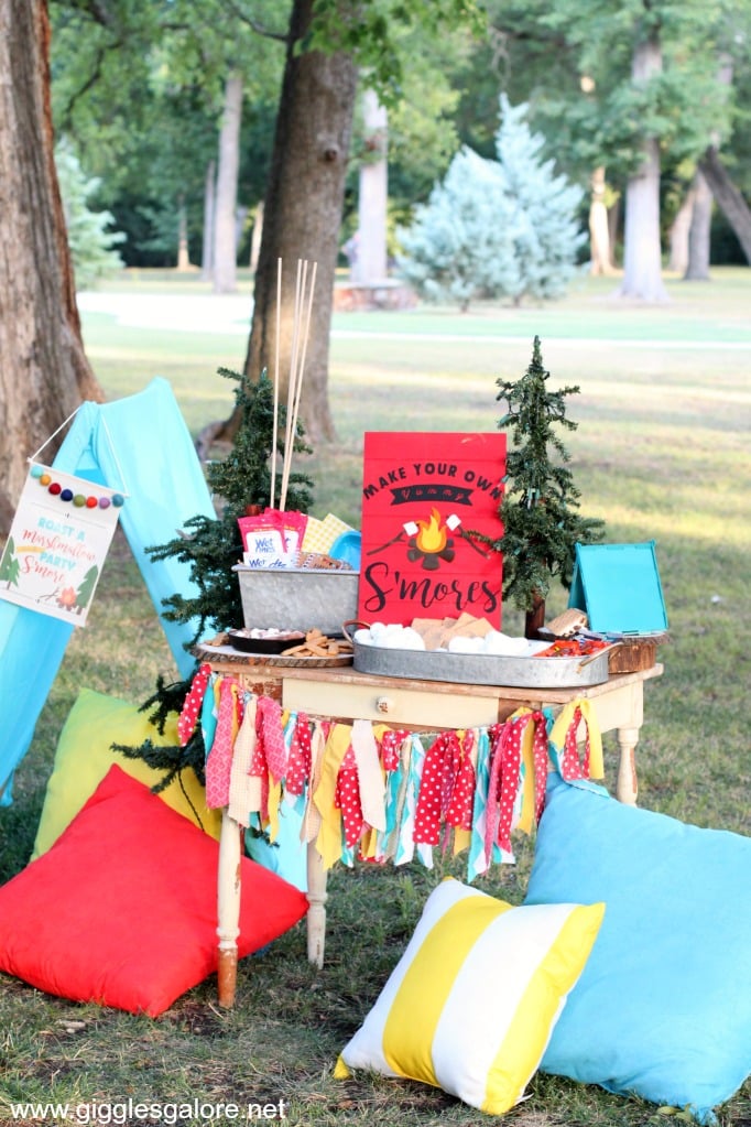 camping themed s'mores bar outside on the grass