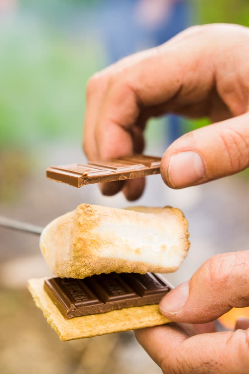 Putting a s'more together from a DIY s'more bar