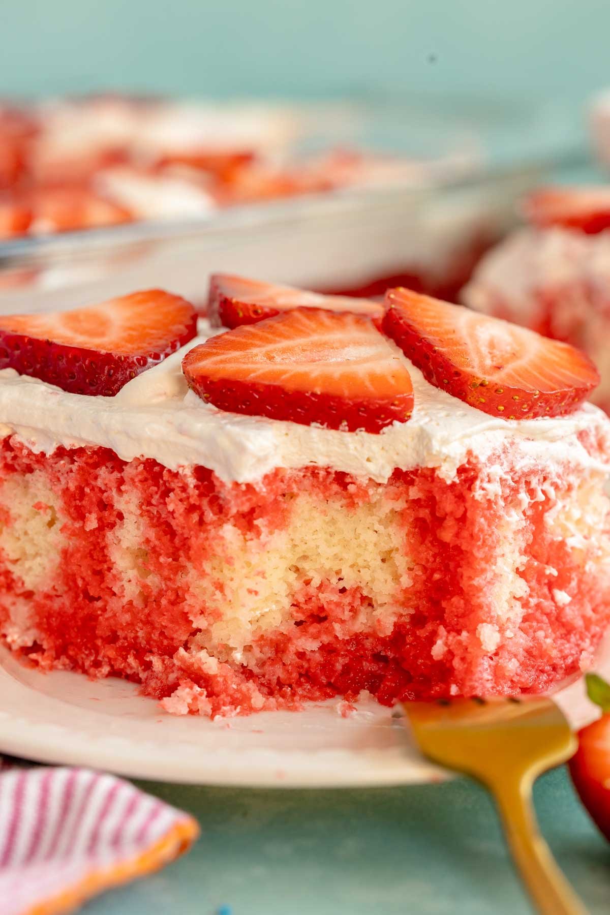 slice of strawberry poke cake on a white plate