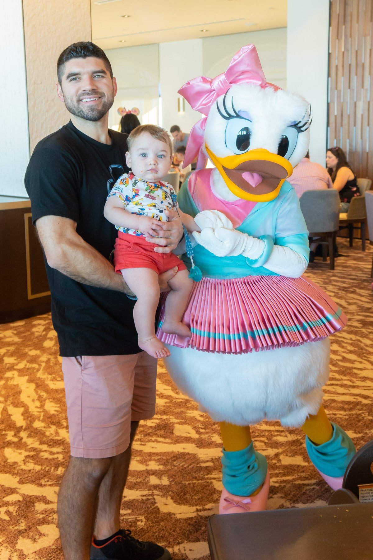 Man and baby with Daisy Duck in ballerina costume