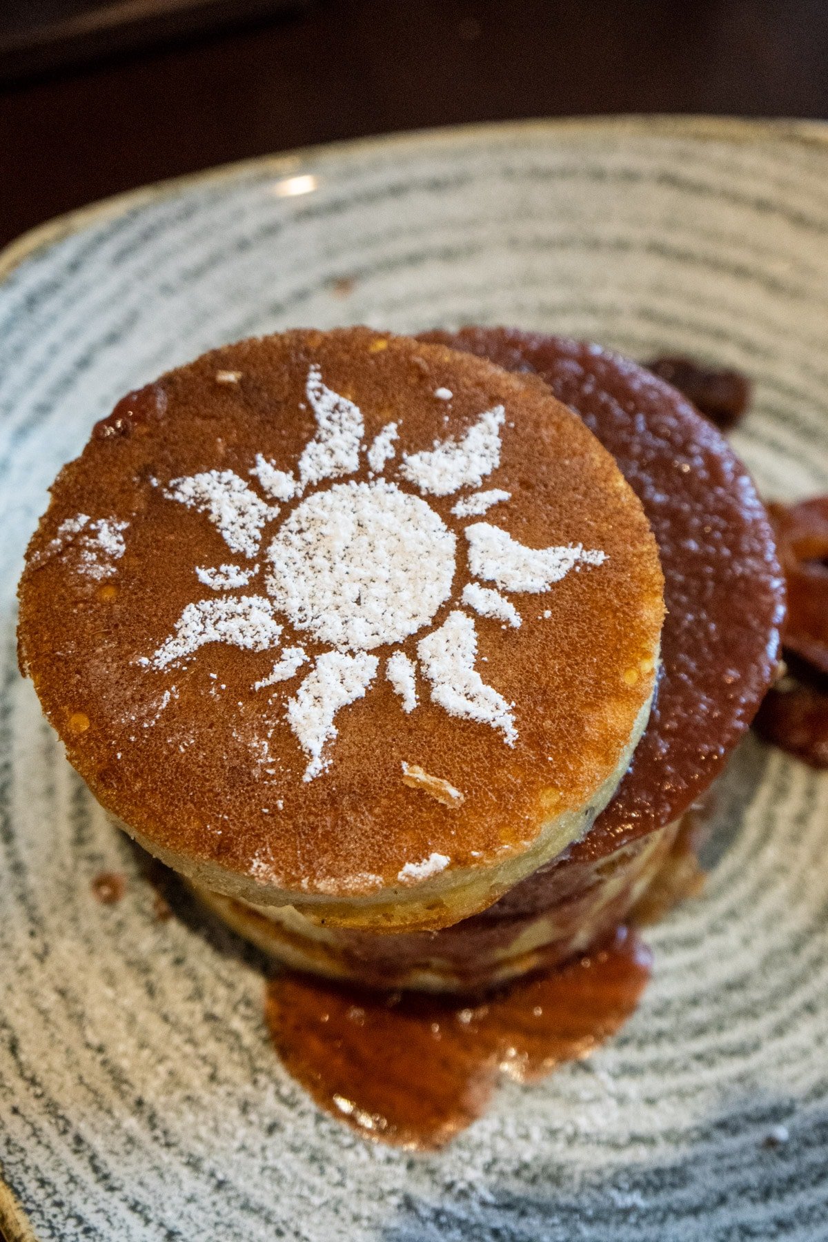 Pancakes with a Tangled symbol on top in powdered sugar