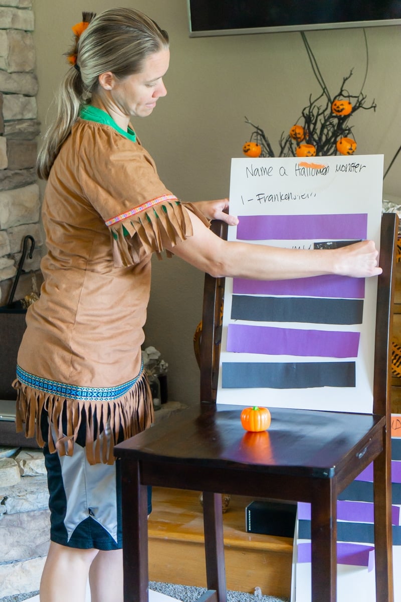 Woman removing paper from correct Halloween Family feud questions